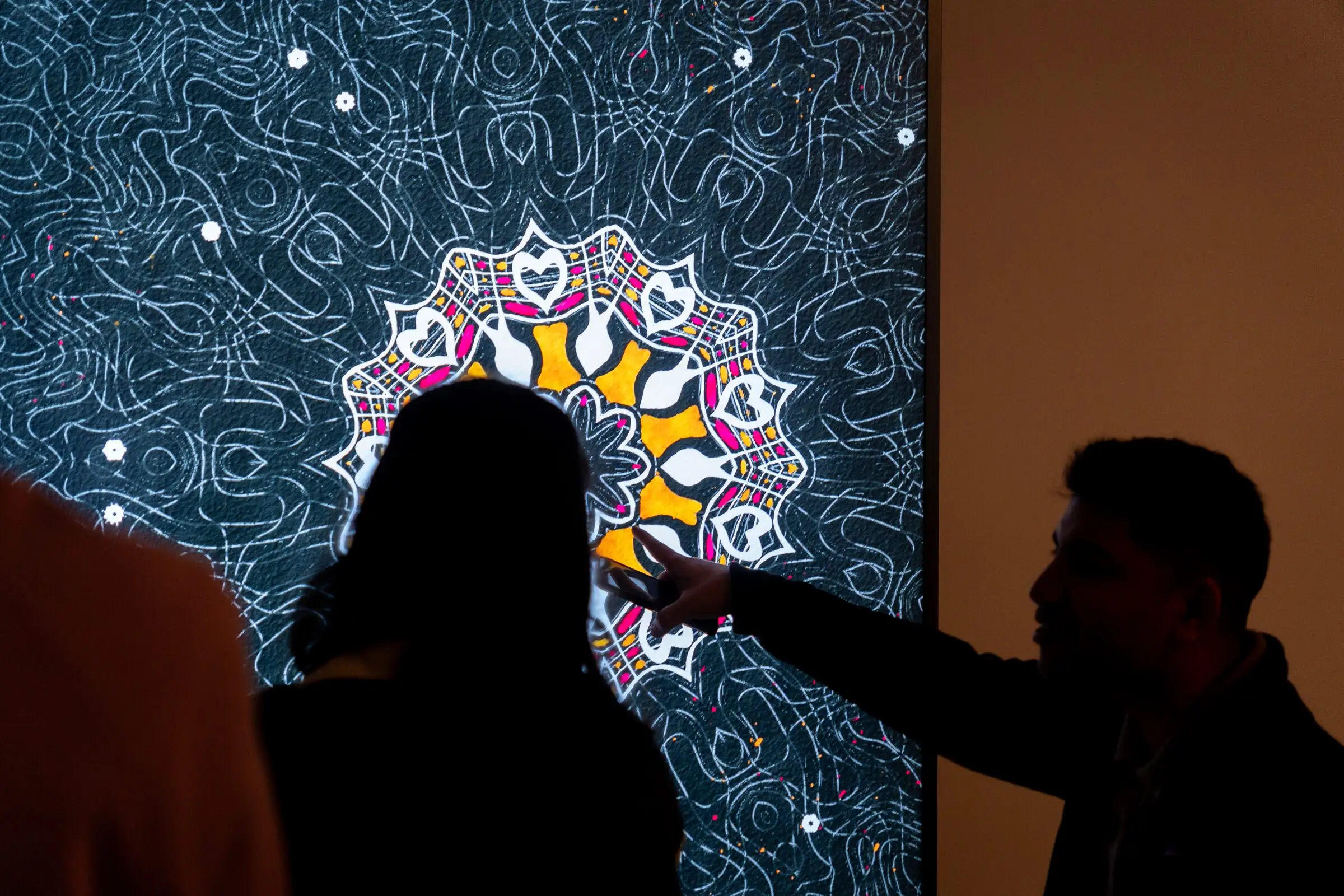 Visitors in silhouette pointing at The Destination on a large screen, Bright Moments Paris.
